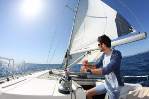 Man sailing with sails out on a sunny day